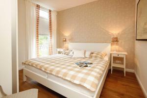 a bedroom with a bed with a plaid blanket and a window at Pier 8 in Ostseebad Karlshagen