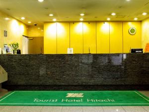 una sala de espera con taquillas amarillas y un suelo verde en Tourist Hotel Hitachi, en Hitachi