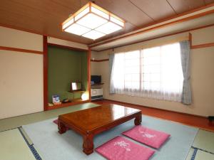 ein Wohnzimmer mit einem Tisch und einem Fenster in der Unterkunft Ikemoto in Nozawa Onsen + 44 Fotos