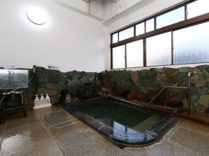 a pool in a room with a couch and windows at Ikemoto in Nozawa Onsen