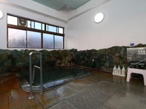 Habitación con baño con bañera de hidromasaje. en Ikemoto, en Nozawa Onsen