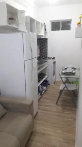 a kitchen with a white refrigerator and a table at HBC 15 in Natal