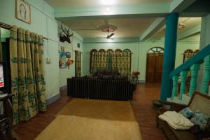 a living room with blue walls and a blue pillar at VAMOOSETRAIL PASIGHAT(1) in Pāsighāt