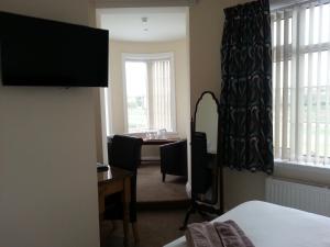 a hotel room with a desk and a bedroom at The Castle Inn in Market Drayton