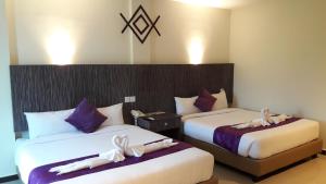 two beds in a hotel room with bows on them at Salsa Resort Langkawi By Casa Loma in Pantai Cenang