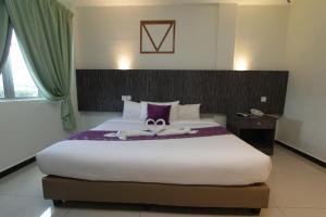 a bedroom with a large bed with two towels on it at Salsa Resort Langkawi By Casa Loma in Pantai Cenang