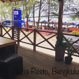 a wooden fence in front of a restaurant with a park at Sinar Sport Hotel in Bengkulu