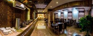 Hotel Grace Majestic في مادغاون: مطعم فيه طاولات وكراسي في الغرفة