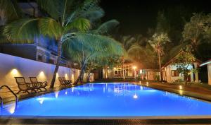 a large swimming pool with blue lighting at night at Arugambay PodBay in Arugam Bay