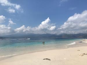 a person standing in the water on a beach at Meno Madia Bungalows in Gili Meno