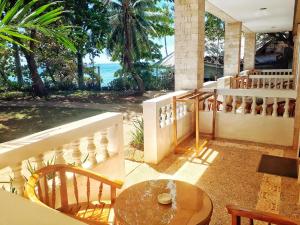 a balcony with a table and chairs and the ocean at La Sirenita in Panglao Island