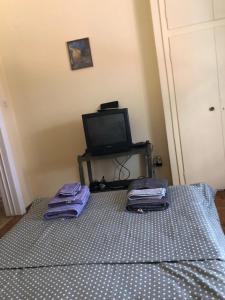 Un dormitorio con una cama con toallas moradas. en Vintage apartment , 700m from metro, en Atenas