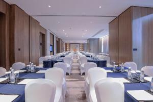 Una larga fila de mesas y sillas blancas en una habitación. en Yuluxe Hotel Chengdu, en Chengdú 65 fotos más