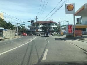an empty city street with a shell gas station at 2bedroom apartment near CONVENTION center in Iloilo City