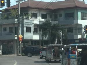 a street with cars and a golf cart in front of a building at 2bedroom apartment near CONVENTION center in Iloilo City