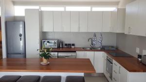 eine Küche mit weißen Schränken und einer hölzernen Arbeitsplatte in der Unterkunft 604 St Tropez in Strand