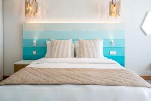 a bed with a blue headboard and white pillows at C Mauritius in Belle Mare
