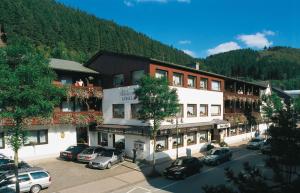 ein großes Gebäude mit auf einem Parkplatz geparkten Autos in der Unterkunft Sporthotel Göbel Garni in Willingen
