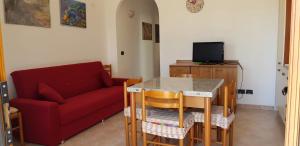 フォチェ・ヴァラーノにあるAppartamento Garganoのリビングルーム(赤いソファ、テーブル付)
