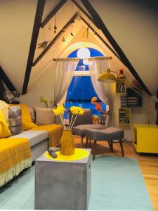 a living room with yellow furniture and a large window at Ålesund downtown loft room with shared bathroom in Ålesund