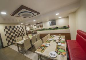 una sala da pranzo con un lungo tavolo e sedie di Hotel iStay a Coimbatore