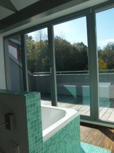 ein Bad mit einer Badewanne und einem Fenster in der Unterkunft Apartmenthotel "Gärtnerhaus Schloss Reinharz" in Bad Schmiedeberg