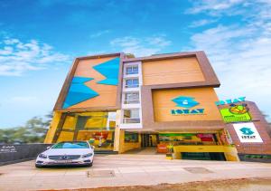 un bâtiment avec une voiture garée devant lui dans l'établissement Hotel iStay, à Coimbatore
