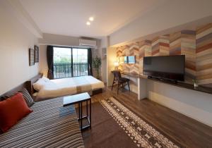 een hotelkamer met een bed en een flatscreen-tv bij e-stay ebisu in Osaka