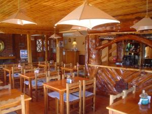 a dining room with wooden tables and chairs at Hosteria Nuevo Pinar in San Carlos de Bariloche