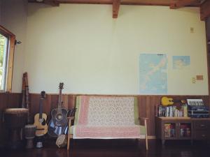 um quarto com uma cama e guitarras num quarto em Guest house iroha em Nakijin