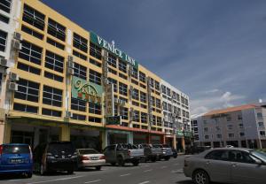 a parking lot with cars parked in front of a building at Venice Inn in Miri