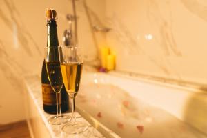 - Uma garrafa de champanhe e 2 copos na banheira; em Eco Tree Hotel Causeway Bay em Hong Kong