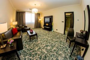 فندق الرويال ريفييرا الدوحة في الدوحة: غرفة معيشة بها أريكة وكراسي وتلفزيون