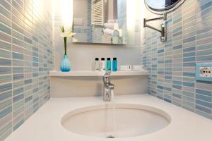 a bathroom with a sink and a blue tiled wall at Sorrento Flats in Sorrento