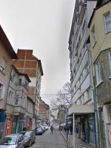 5th Avenue Sofia | Two Bedroom, Two Bathroom, Positano Street Suite في صوفيا: شخص يمشي على شارع المدينة بالمباني