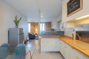 a kitchen with white cabinets and a refrigerator at la roche gauthier 4 personnes in Gérardmer