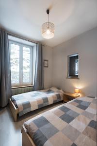 a bedroom with two beds and a window at la roche gauthier 4 personnes in Gérardmer