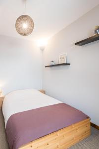 a bedroom with a bed and shelves on the wall at la roche gauthier 4 personnes in Gérardmer