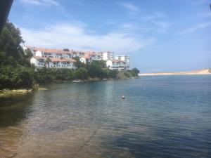 a large body of water with buildings in the background at El Pinar de Mogro in Mogro