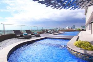 a swimming pool on the roof of a building at Acacia Hotel Manila in Manila