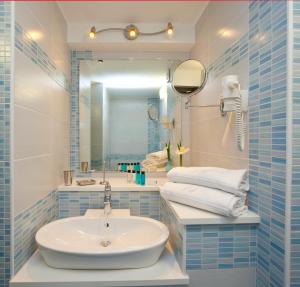 a bathroom with a sink and a mirror and towels at Sorrento Flats in Sorrento