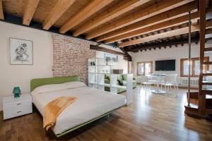 een slaapkamer met een bed en een woonkamer bij Loft Mirano (Alloggi alla Campana) in Mirano
