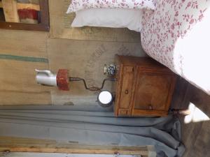 a bathroom with a toilet paper dispenser next to a bed at La chouette étoilée in Auxon