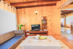 a living room with a table and a tv at Sarah Cottage Nuwara Eliya in Nuwara Eliya