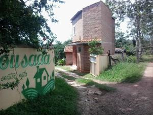 a building with a sign in front of a yard at Pousada Sitio Urbano in São José da Barra