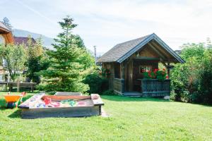 a log cabin with a sandbox in the yard at Appartement Haus Moser in Sankt Michael im Lungau
