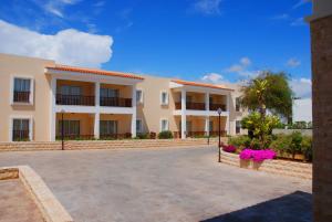 a large apartment building with a parking lot at Aktea Beach Village in Ayia Napa