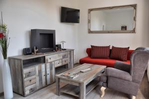 a living room with a red couch and a television at Domfreiheit in Naumburg