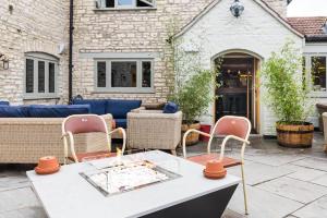 a patio with wicker chairs and a table at The Litton in Litton