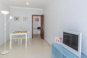 a living room with a table and a tv at FLH Muralhas da Vila Apartment in Albufeira